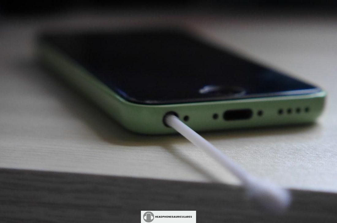 Usar un hisopo para limpiar la toma de auriculares del iPhone