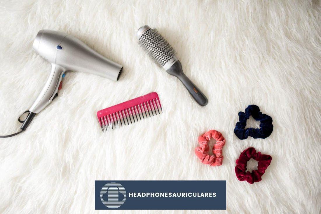 Diferentes herramientas y productos para peinar el cabello dispuestos sobre una superficie plana.  (De: Pexels)