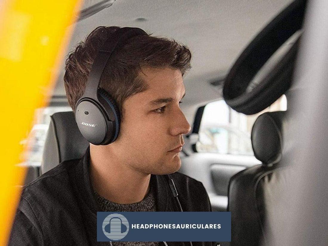 Hombre usando audífonos con cancelación de ruido Bose (De: Headphonesty)