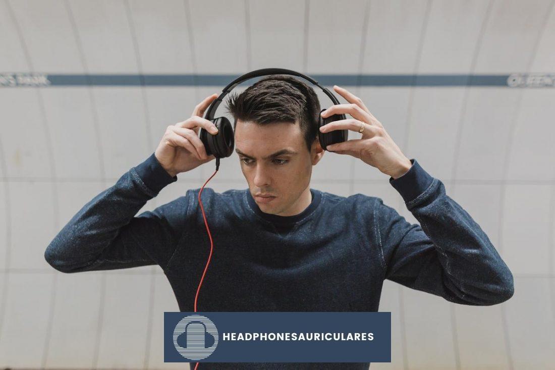 Foto de un hombre que parece inseguro sobre el uso de unos auriculares acolchados (De: pixabay.com)