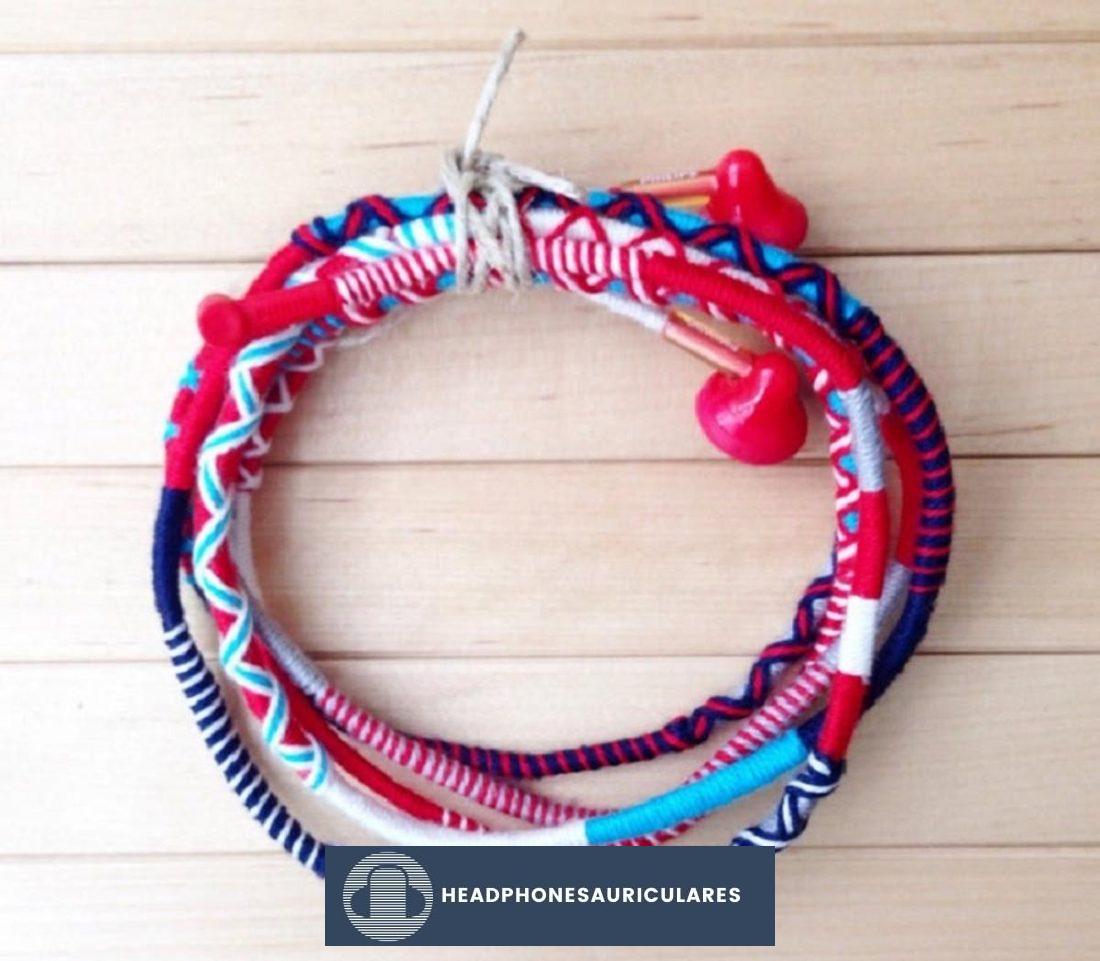 Envuelve los cables de tus auriculares con hilos de colores o hilos de bordar para que no se enreden.  (De: Etsy)