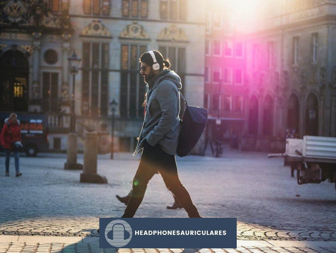 Hombre caminando afuera mientras escucha música (De: Pexels)