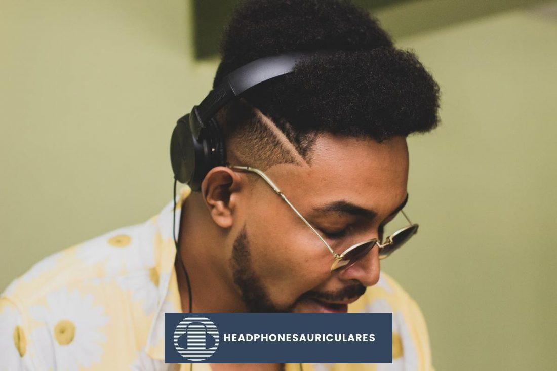 Un hombre que usa audífonos tiene el cabello aplastado por la diadema.  (De: Unsplash)